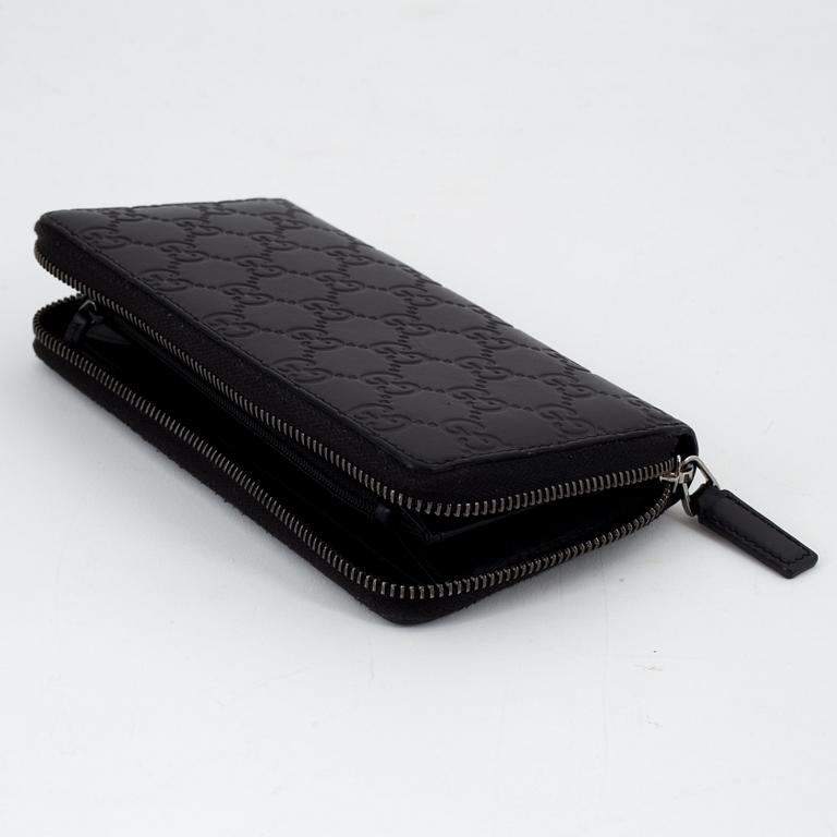 Gucci, an embossed böack leather wallet.