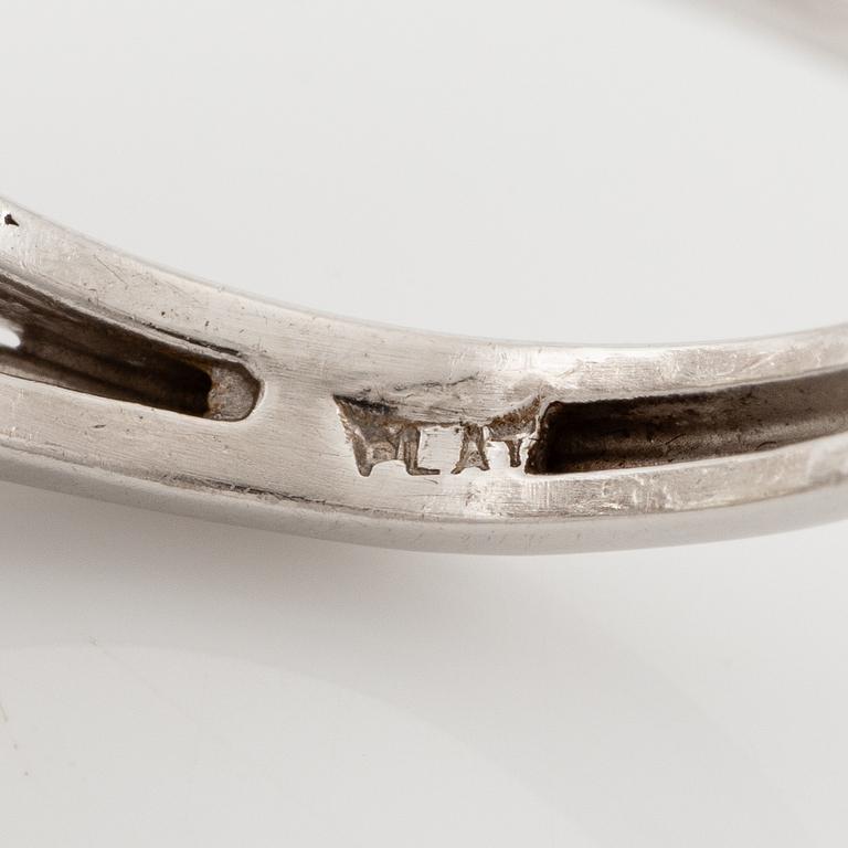 A platinum ring set with a pear-shaped yellow diamond and round brilliant-cut diamonds.