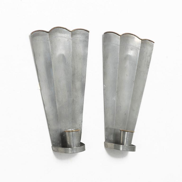 Nils Fougstedt, a matched pair of pewter and brass wall sconces, model A 60, Svenskt Tenn, Stockholm 1929 and 1932.