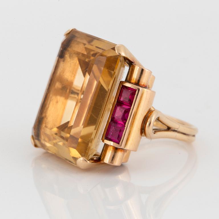 A 14K gold ring set with a faceted citrine and rubies.