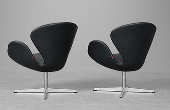 A pair of Arne Jacobsen dark grey leather "Swan" easy chairs, Fritz Hansen, Denmark 2008.