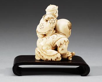 A carved ivory figure of two boys playing with at turtle, Qing dynasty.
