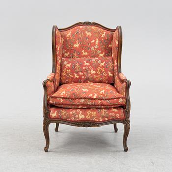 A Louis XV style easy chair from around the year 1900.