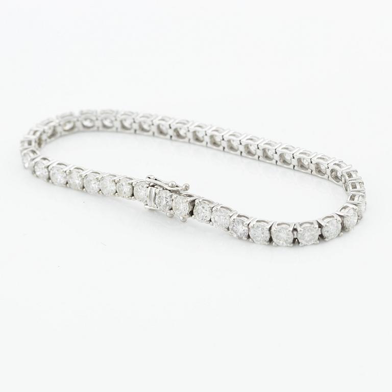 An 18K gold tennis bracelet with round brilliant-cut diamonds.