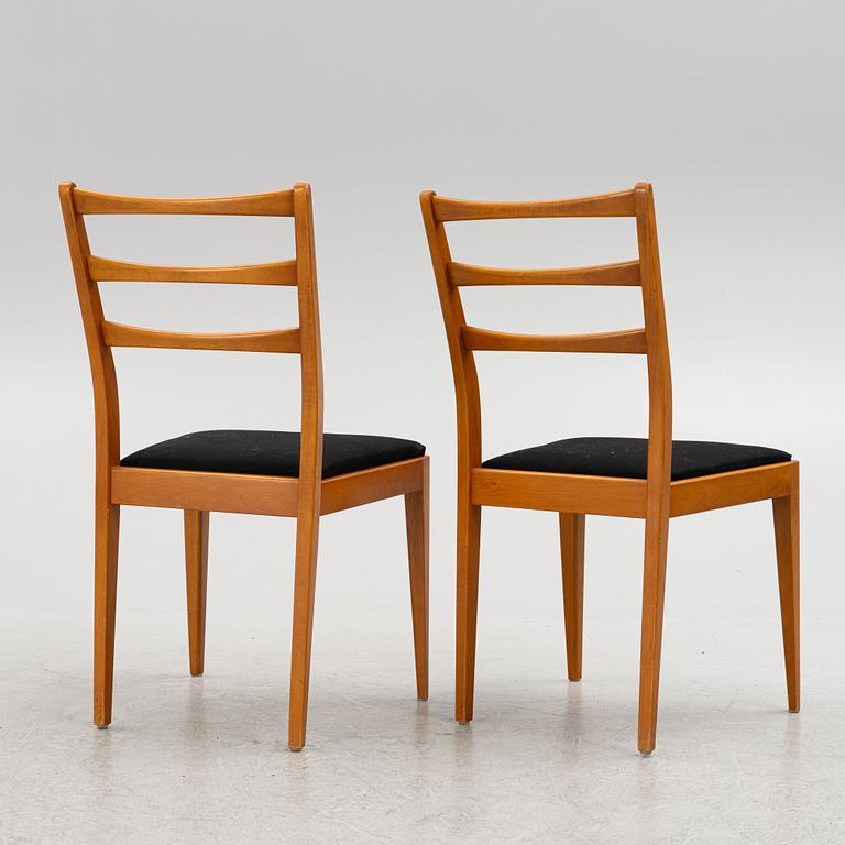 A dining table with four chairs, mid 20th century.