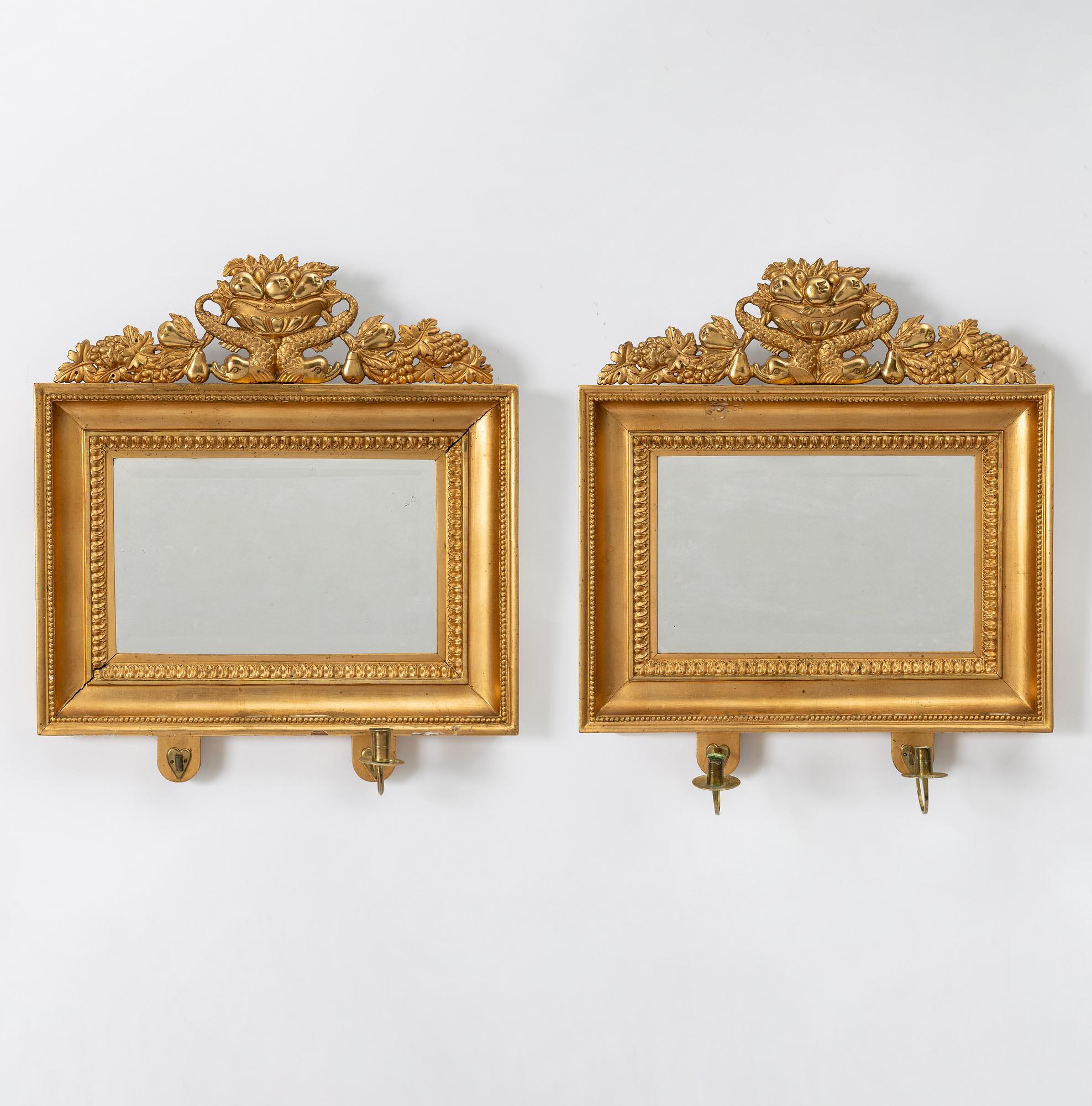 A pair of Late Empire gilded mirror sconces for two candles, Gothenburg, 1830s-40s.