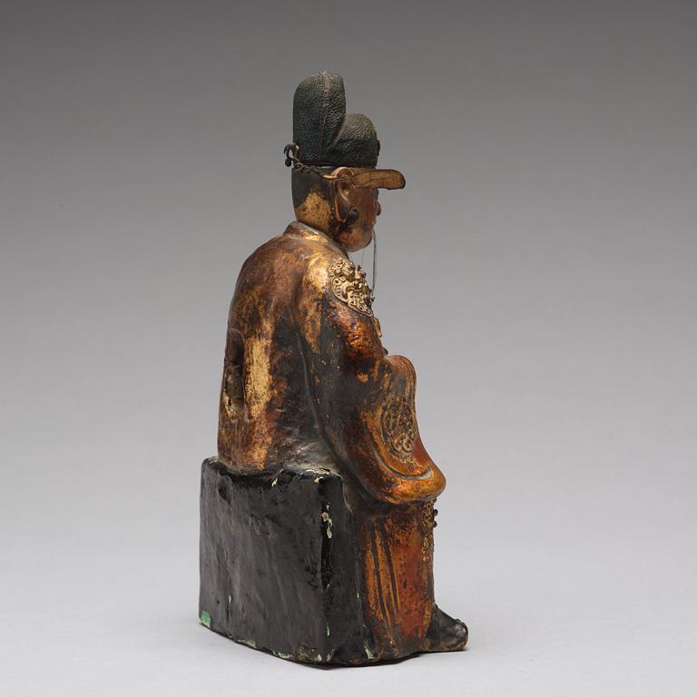 A lacquered and gilt ceramic sculpture of a deity, Ming dynasty (1368-1644).