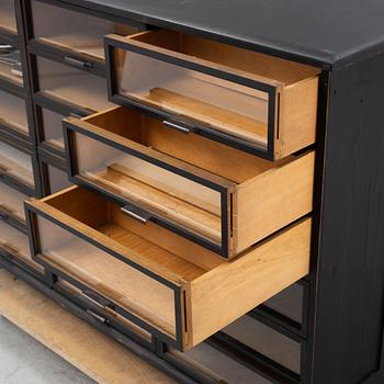 A painted desk with drawers with glass fronts.