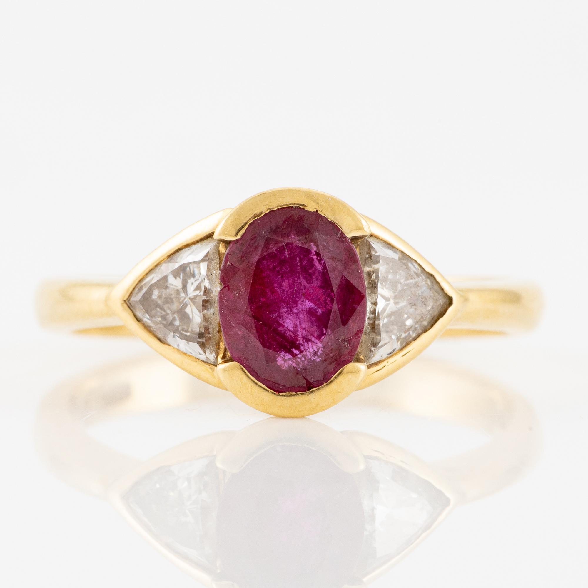 Ring 18K guld med en fasettslipad rubin samt två triangelformade briljantslipade diamanter.