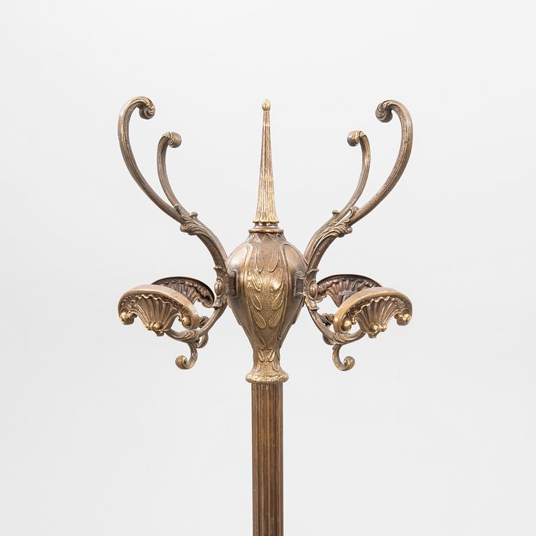 A brass coat hanger from the first half of the 20th century.