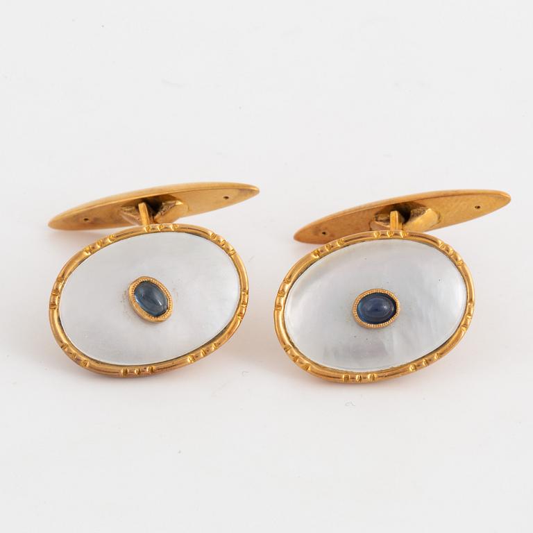 18K gold cufflinks with mother of pearl and cabochon-cut sapphire.