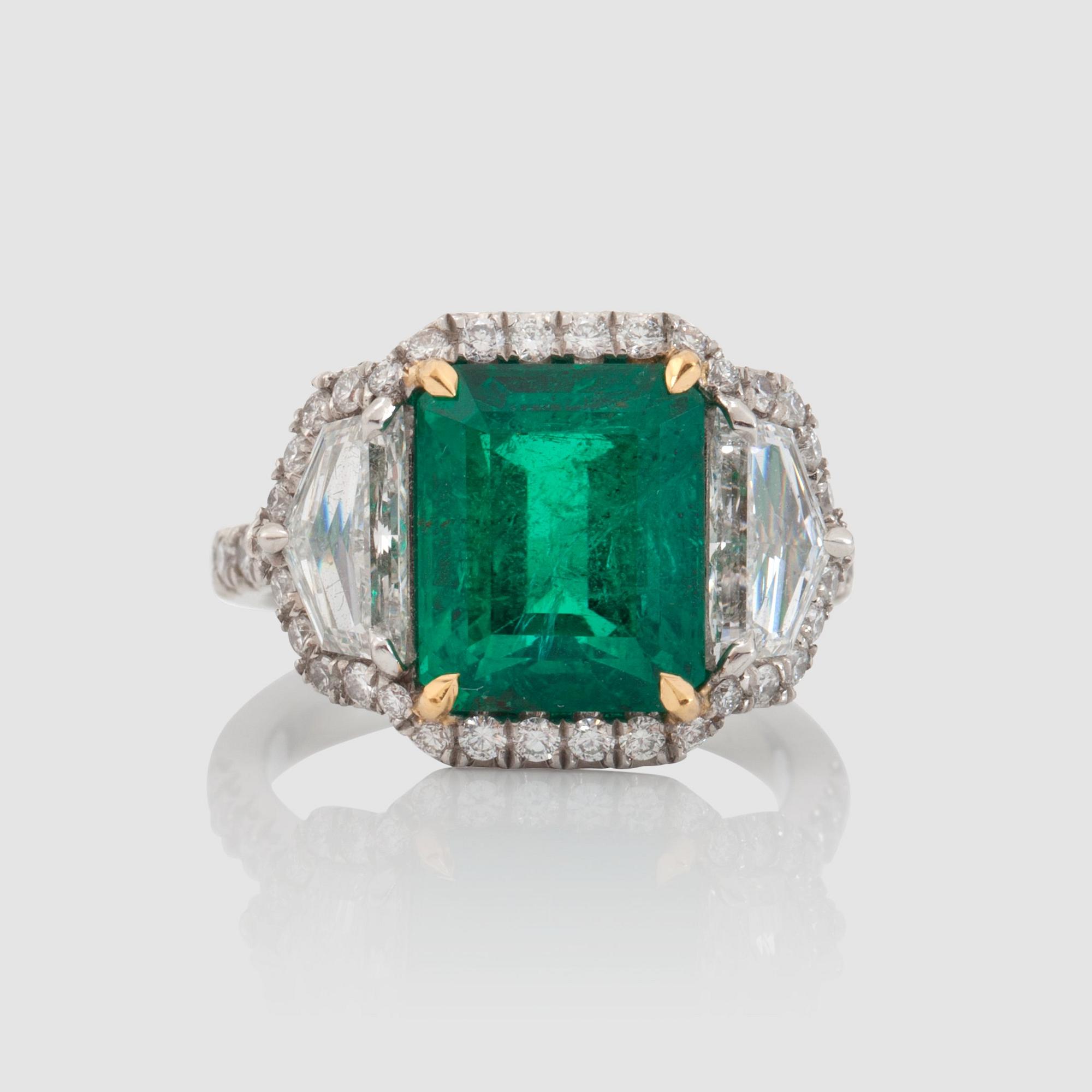 Ring med smaragd, 5.50 ct, epaulettslipade sidostenar totalt 1.55 ct, och pavéfattade briljanter, totalt ca 0.80 ct .