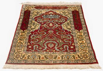 A silk and metal Hereke rug, c. 86 x 52 cm.