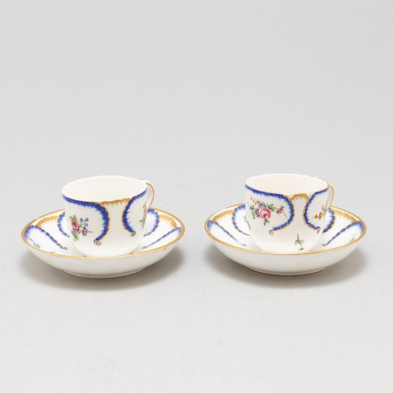 A pair of enamelled cups with dishes, France, Sèvres, 1780s.