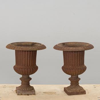 A PAIR OF IRON CAST GARDEN URNS.