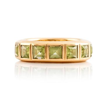 527. An 18K gold ring set with step-cut peridots.
