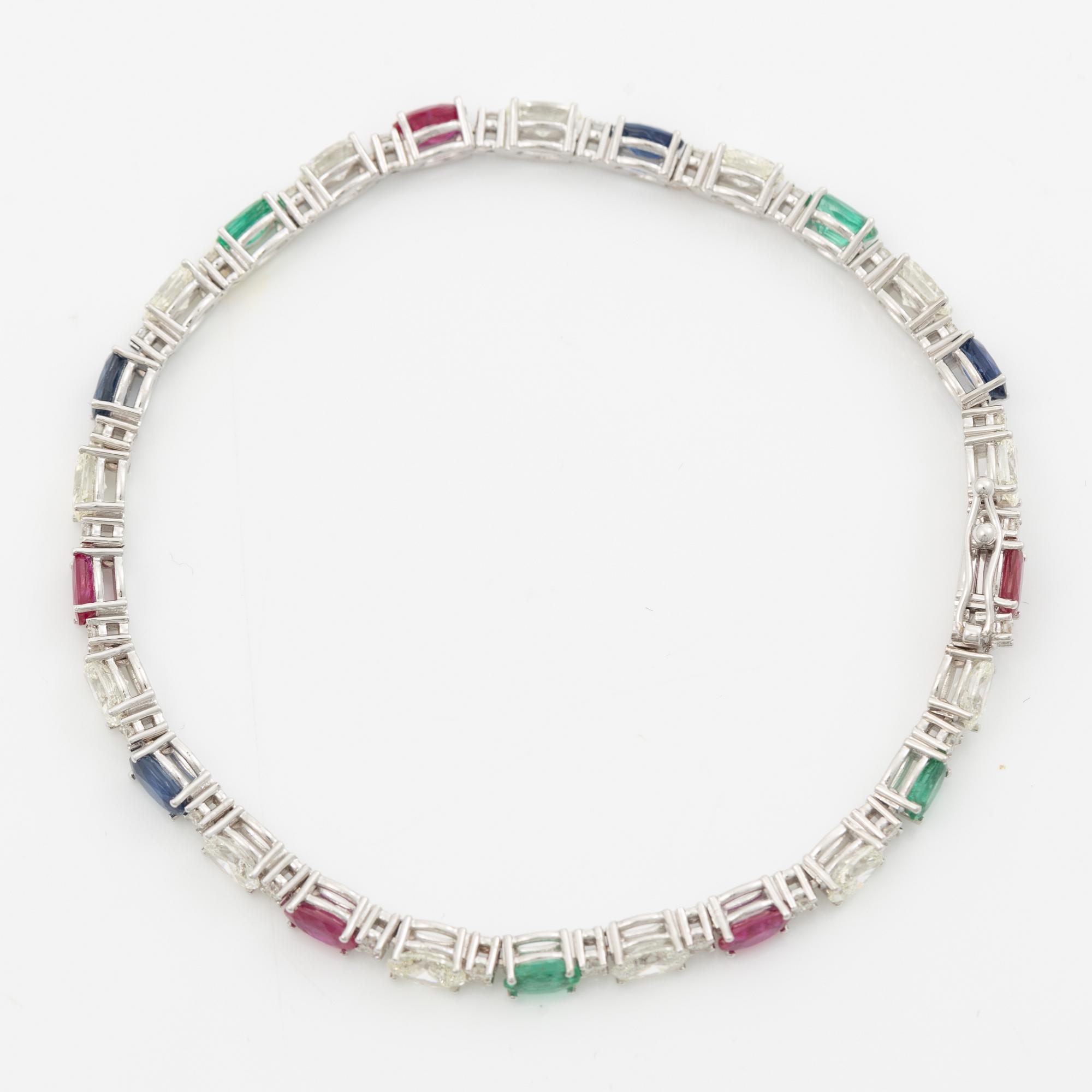 Bracelet 18K white gold set with faceted rubies, emeralds, sapphires, and round brilliant-cut diamonds.