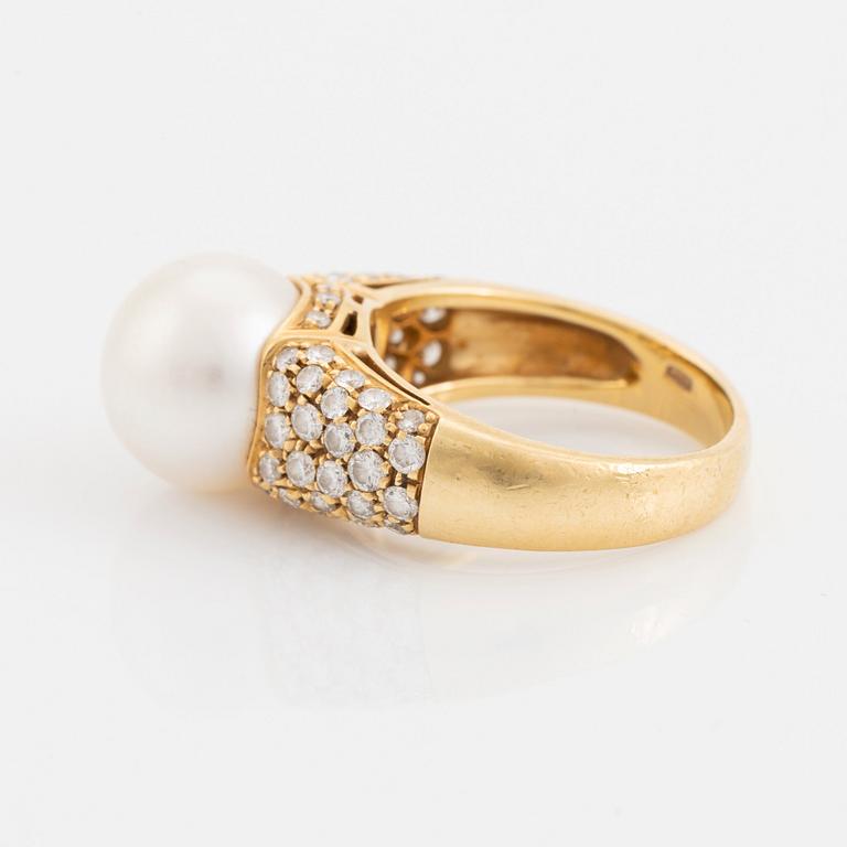 An 18K gold ring set with a cultured South Sea pearl and round brilliant-cut diamonds.