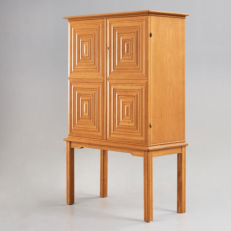 A Swedish Modern oak cabinet on stand attributed to Oscar Nilsson, 1940's.