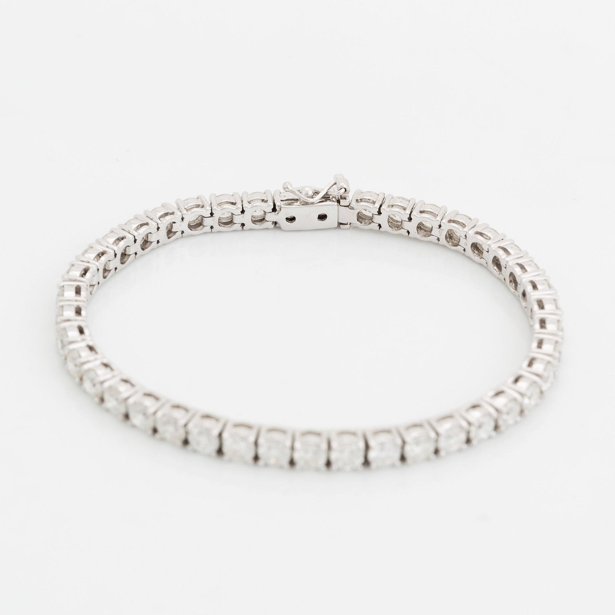 An 18K white gold bracelet set with round brillliant-cut diamonds.