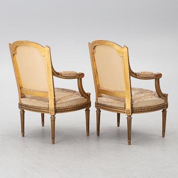 A pair of Louis XVI-style armchairs, late 19th century with 18th century fabric.
