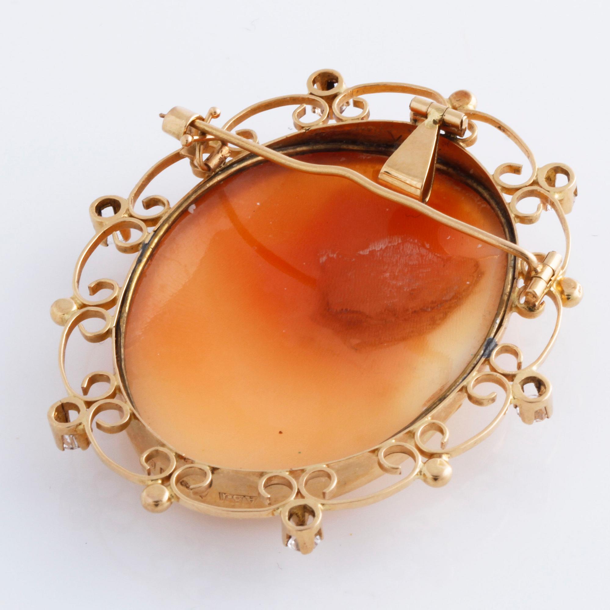 A cameo and white gemstone brooch.