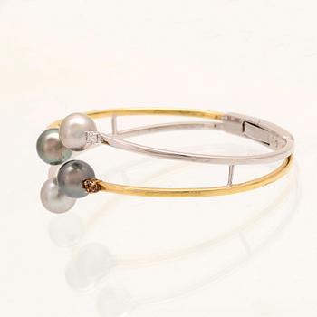 An 18K white- and yellow gold bracelet with round brilliant cut diamonds and cultured Tahitian pearls, Damiani Italy.