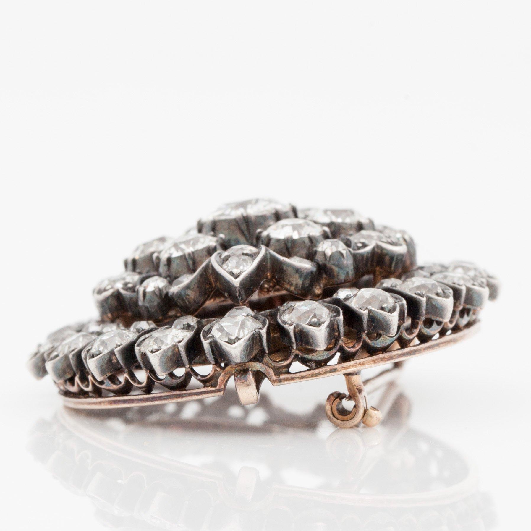 BROSCH med gammalslipade diamanter totalt ca 9.40 ct, mittsten ca 1.10 ct.