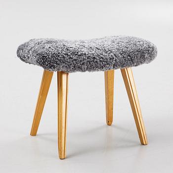 A birch stool with new sheepskin upholstery.