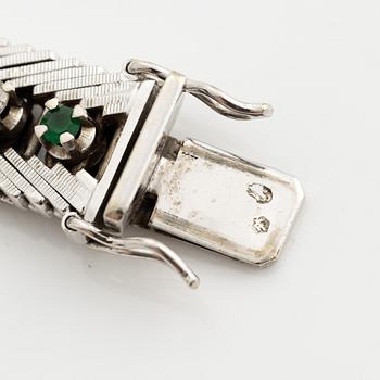 Bracelet 18K gold with round brilliant-cut diamonds and green stones, likely emeralds.