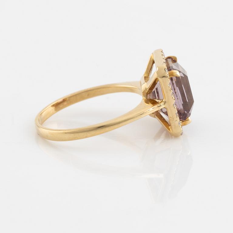 An 18K gold and ametrine ring set with round brilliant-cut diamonds.