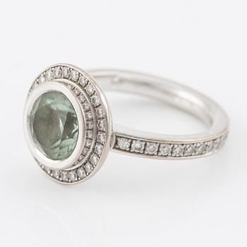 Ring, 18K white gold set with a round faceted green beryl and brilliant-cut diamonds.