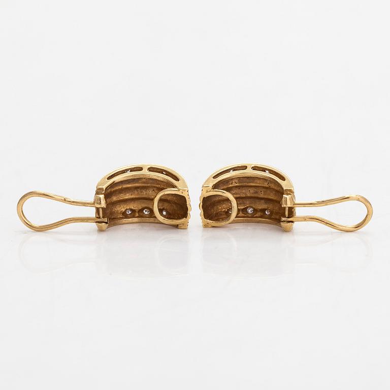 A pair of 18K gold earrings set with small diamonds.