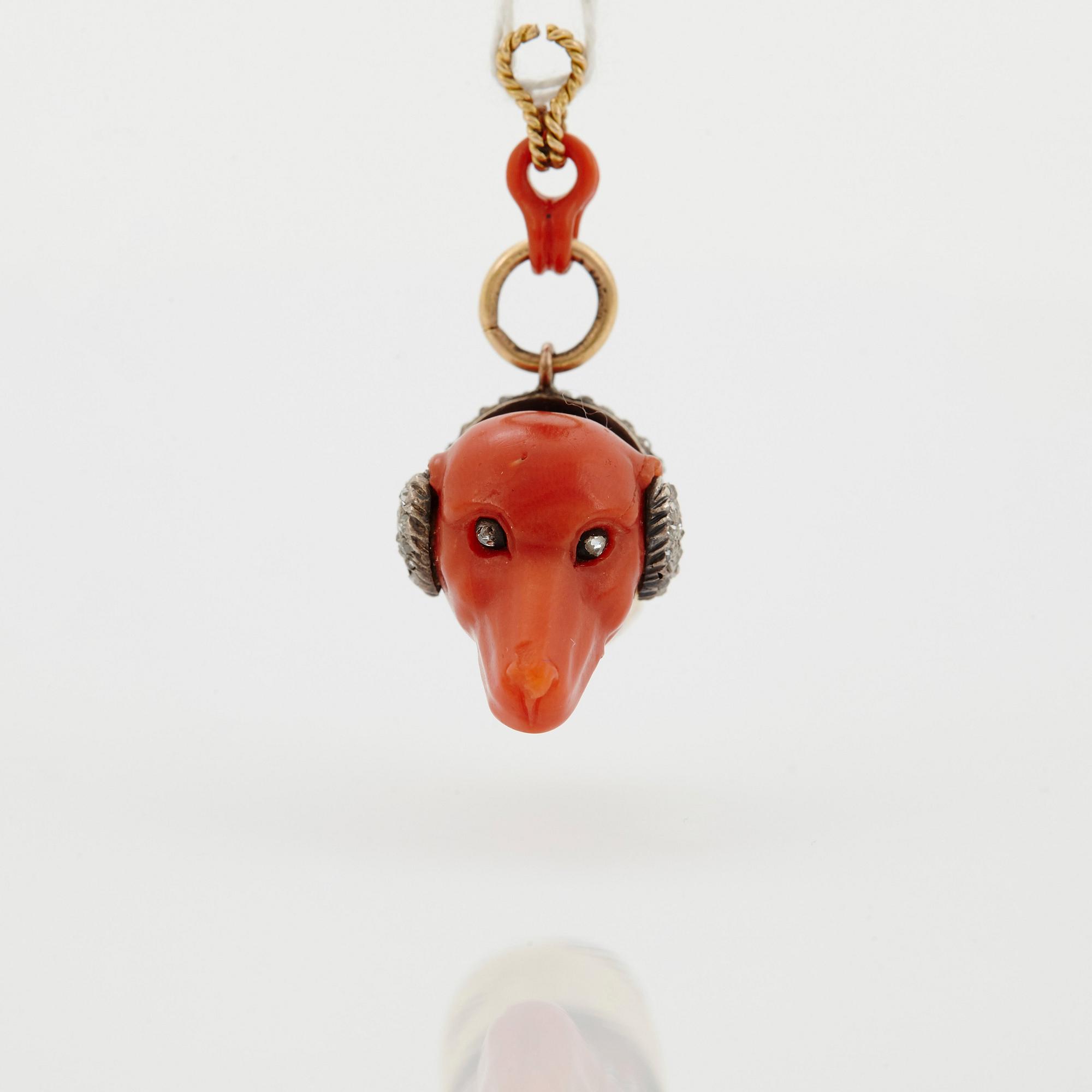 A 14 K gold and silver pendant with carved coral set with rose-cut diamonds.