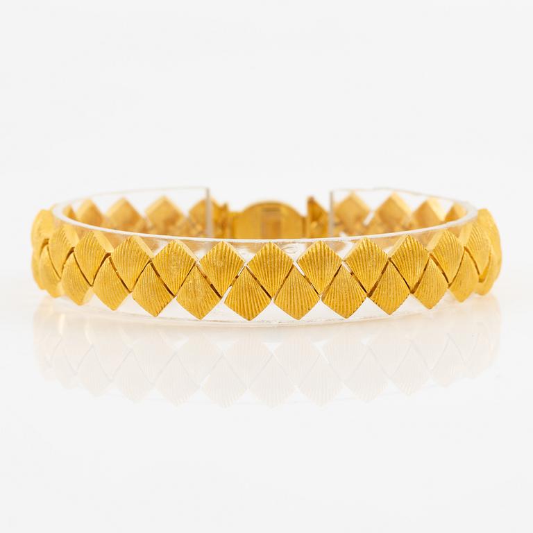 Garnityr av guldsmycken, en collier (14K), ett armband (18K), ett par örhängen (14K) och en ring (14K).