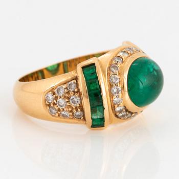 An 18K gold ring set with a cabochon-cut emerald.