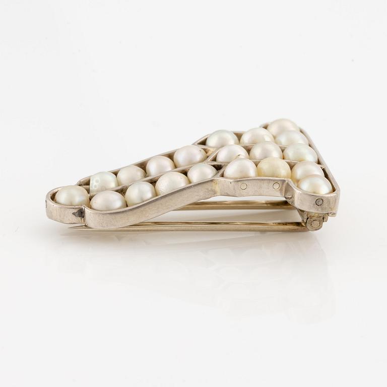 A brooch in 18K white gold set with natural pearls.