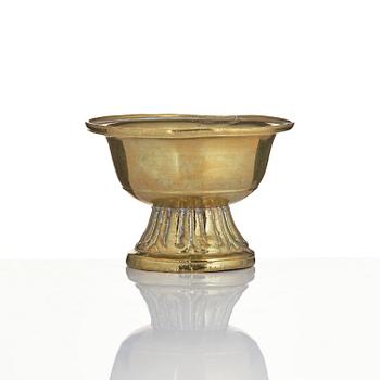 A bronze deity and a brass sacrificial bowl, Tibet, circa 1900.