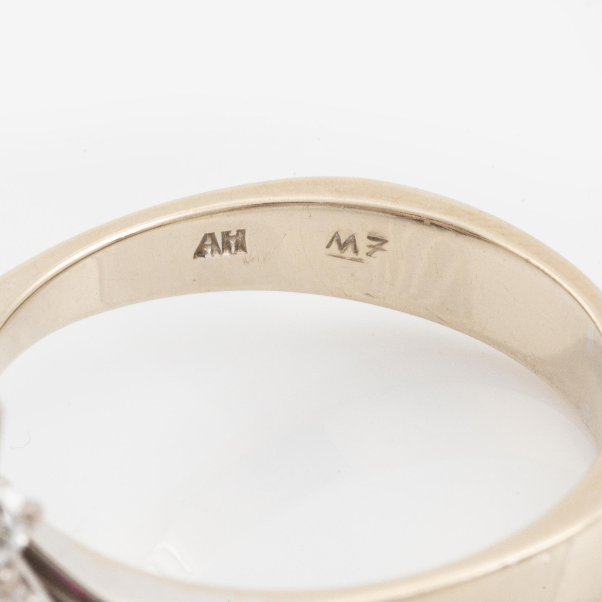 Ring 18K guld med en fasettslipad rubin samt runda briljantslipade diamanter.