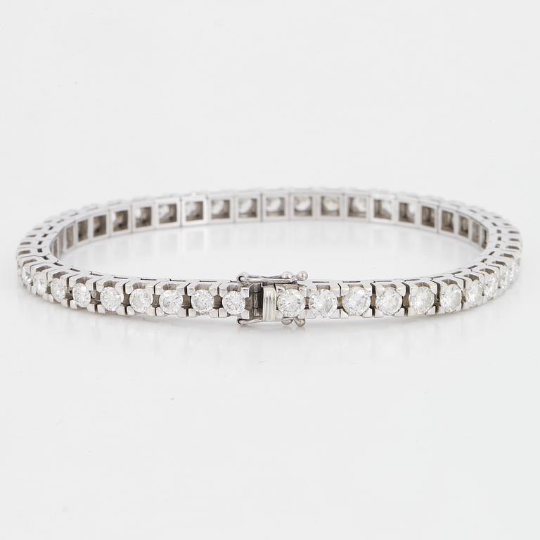 An 18K white gold tennisbraclet set with round brilliant-cut diamonds.