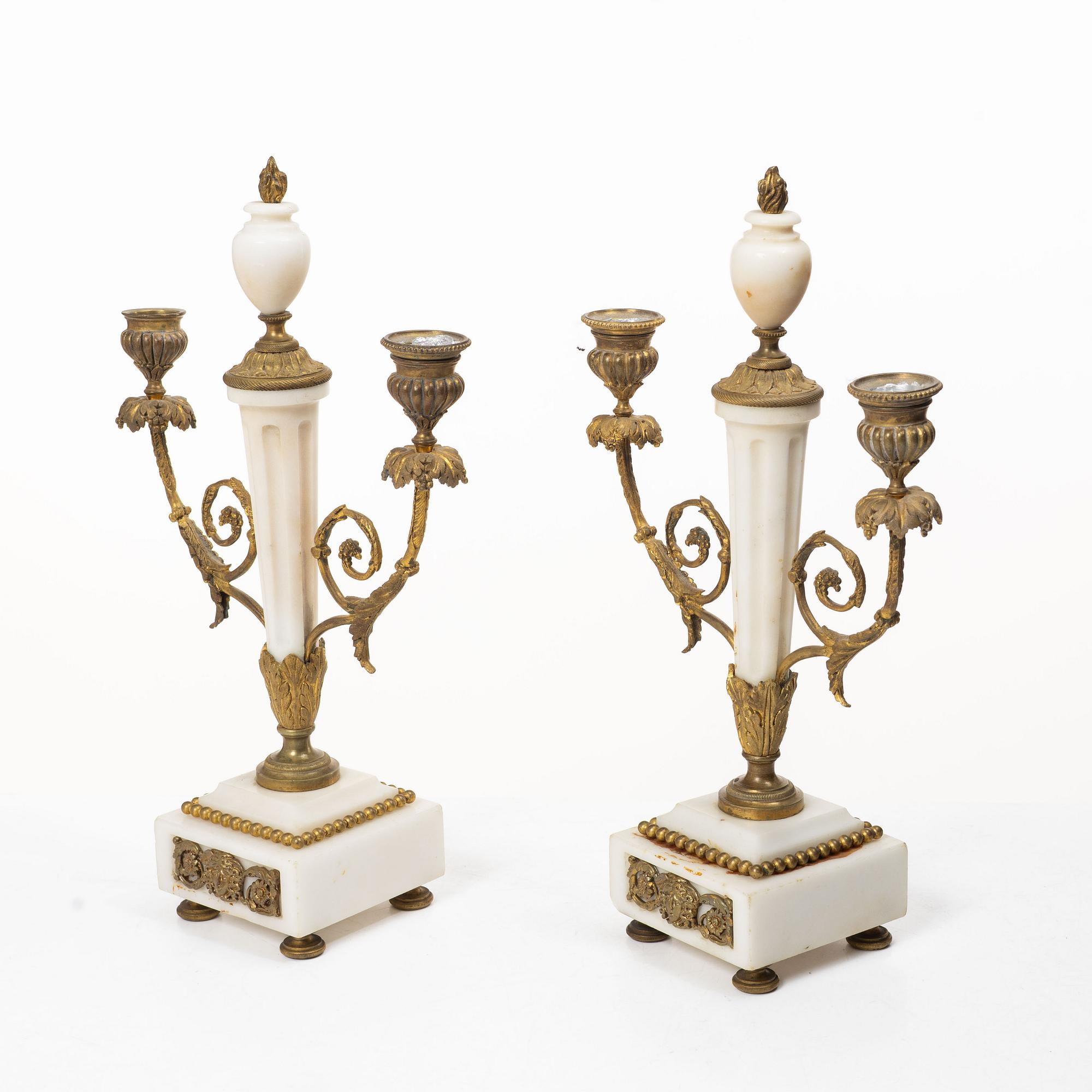 A Louis XVI-style mantle clock and a pair of candelabras. Early 20th century.