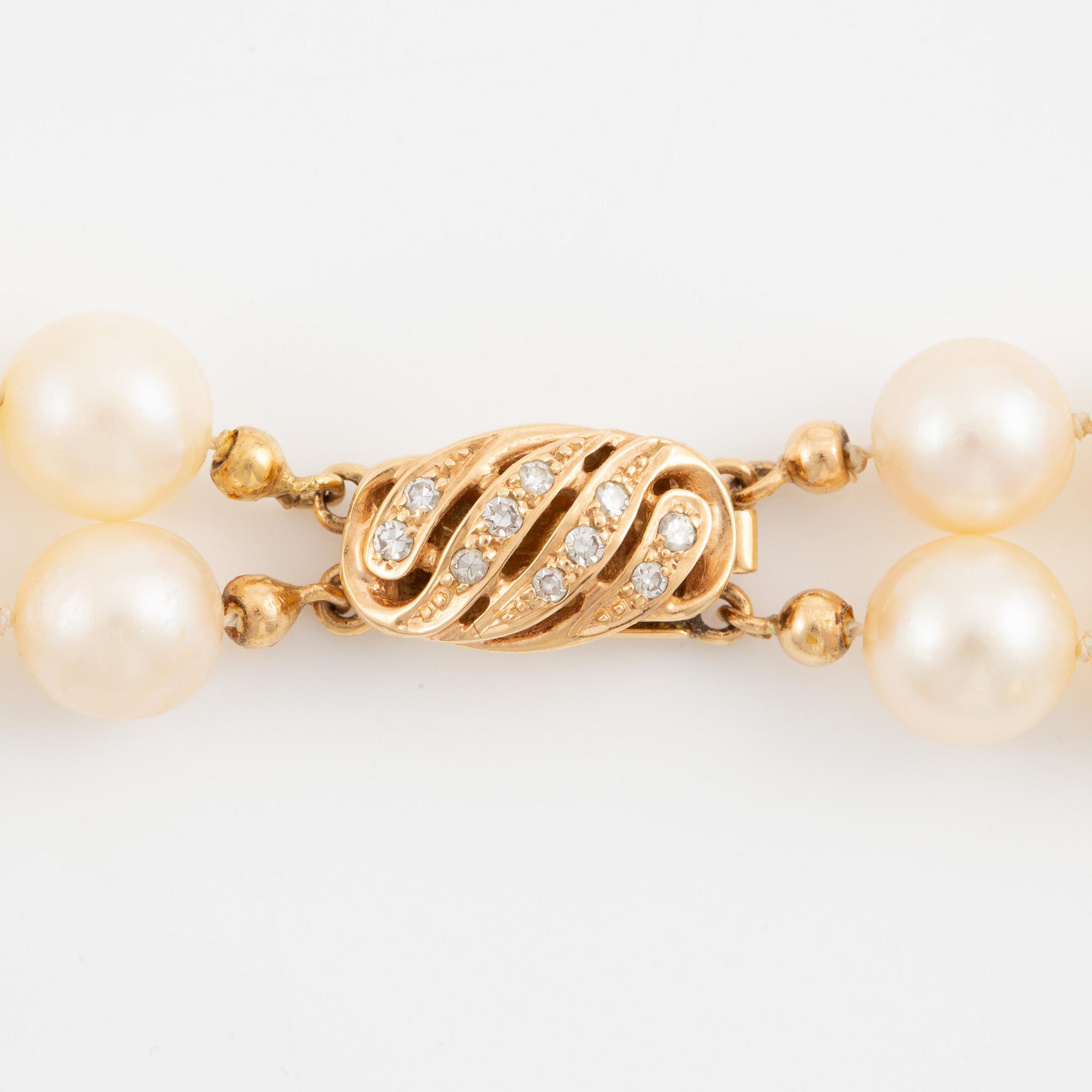 Necklace of two strands of cultured pearls, clasp with 18K gold lock set with eight-cut diamonds.