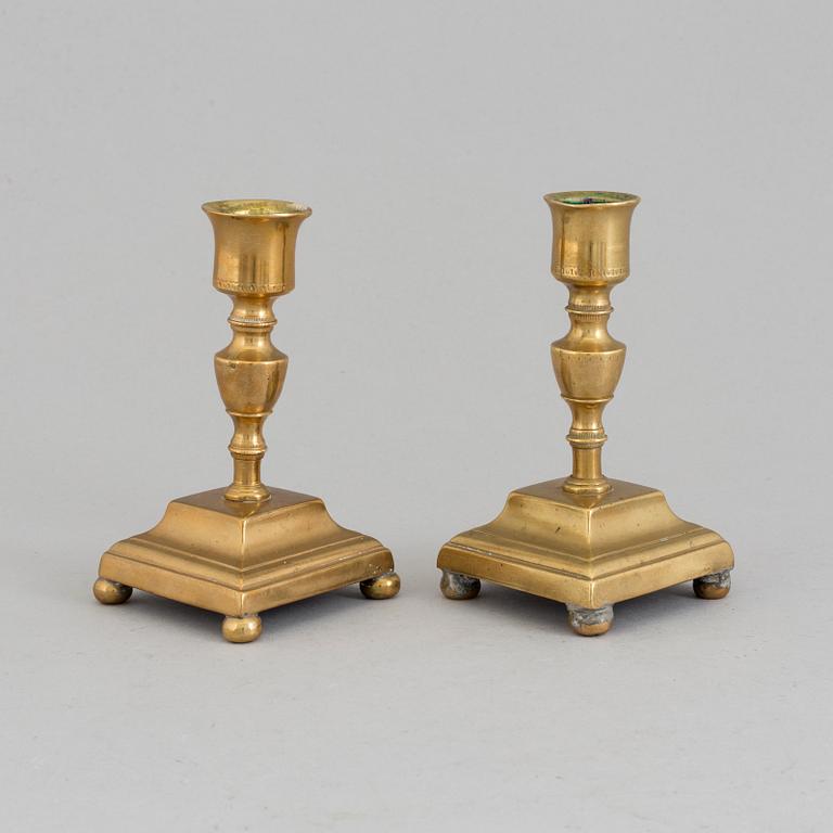 A pair of brass candlesticks, 18th Century.