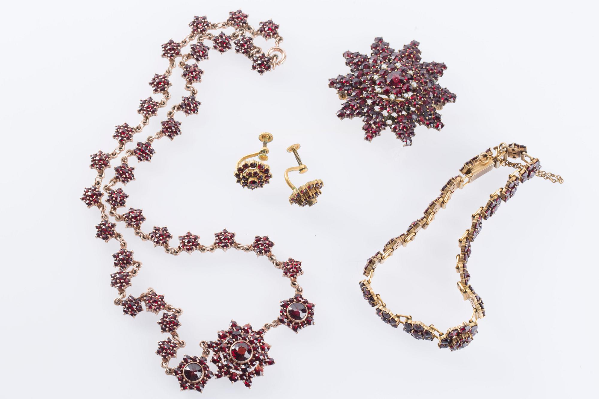 HALSBAND, BROSCH, ARMBAND samt ÖRHÄNGEN, ett par, med fasetterade granater, troligen omkring sekelskiftet 1900.