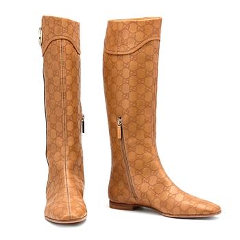 GUCCI, a pair of beige monogram leather boots.