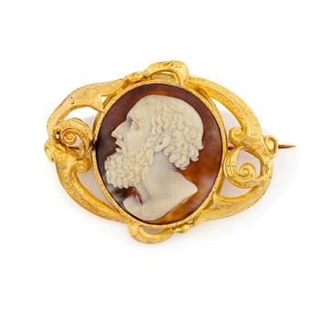 558. An 18K gold brooch with a hardstone cameo.