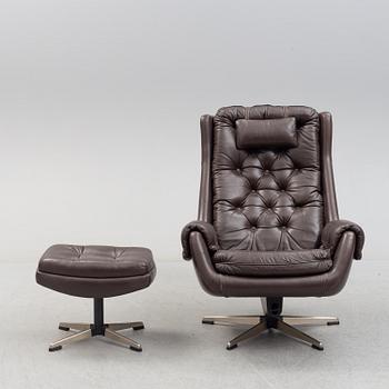 A leather upholstered easy chair with foot stool, 1960's/70's.