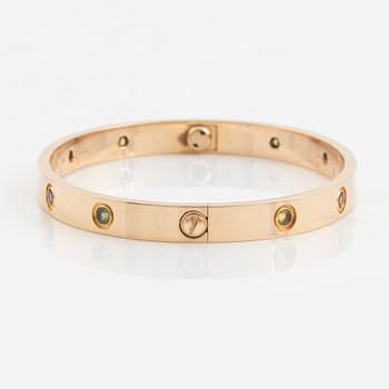 A Cartier "Love" bracelet in 18K rose gold set with colored stones.