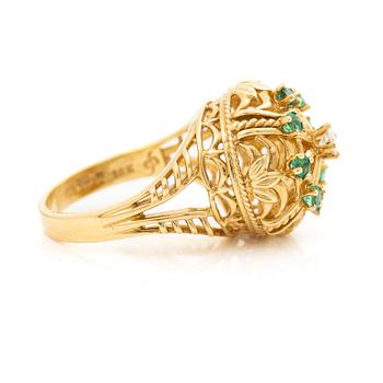 18K gold ring with small emeralds and a round brilliant-cut diamond.