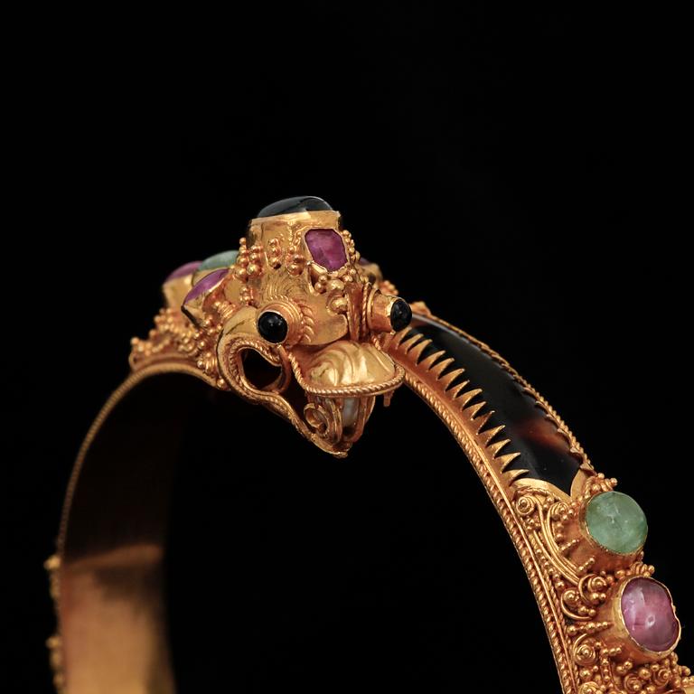 ARMBAND, 22k guld med flertal trumlade ädelstenar, bla. rubiner och smaragder. Vikt 26,9 g.